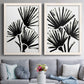 Set of two white barnwood framed canvas prints depicting paired bold monochrome botanical prints with radiating brush marks, repeated leaf-like fans, and white grounds above a sofa in a contemporary living room.