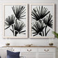 Set of two white barnwood framed canvas prints depicting a coordinated art pair of black fan-shaped botanical forms rendered as bold monochrome botanical prints above a dining room sideboard.