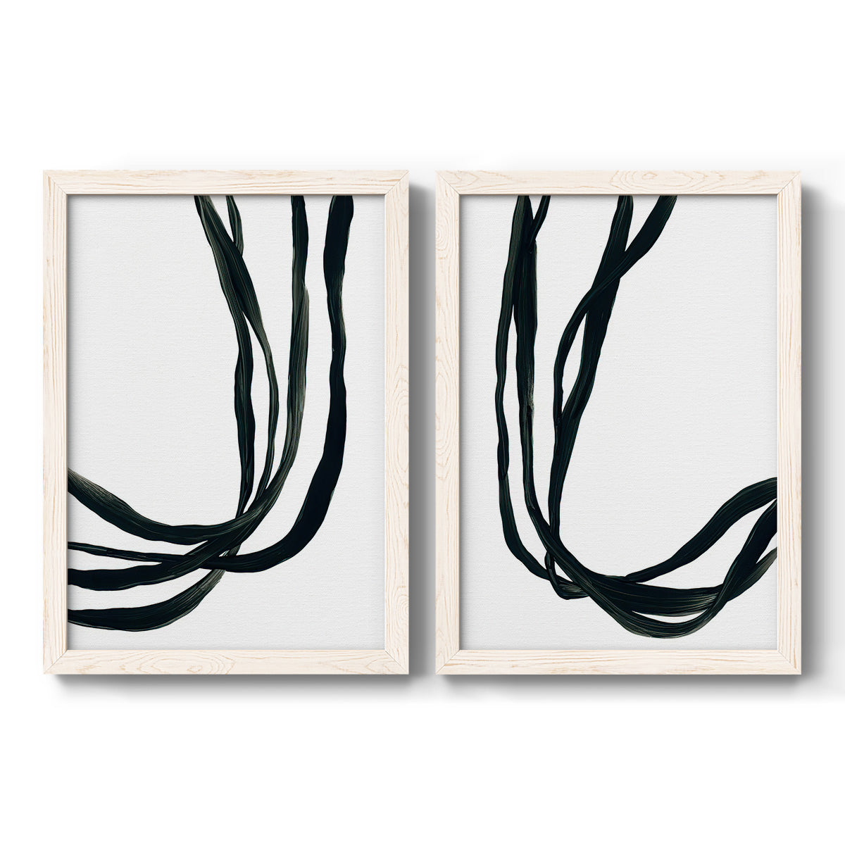 Set of two white barnwood framed canvas prints featuring two minimalist gestural line abstracts featuring flowing black ribbon-like lines.