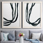 Set of two white barnwood framed canvas prints depicting paired minimalist gestural line abstracts with thick looping strokes, white space, and elegant vertical movement above a sofa in a contemporary living room.