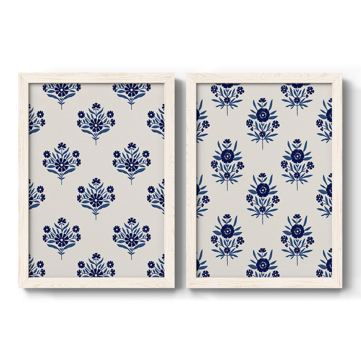Set of two white barnwood framed canvas prints featuring two repeating blue floral patterns with stylized bouquets arranged across warm white backgrounds.