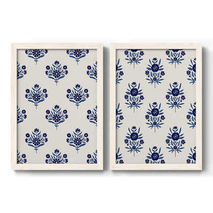 Set of two white barnwood framed canvas prints featuring two repeating blue floral patterns with stylized bouquets arranged across warm white backgrounds.