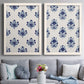 Set of two white barnwood framed canvas prints depicting graphic block print bouquets with symmetrical leaves blossoms and bold indigo coloring above a sofa in a contemporary living room.