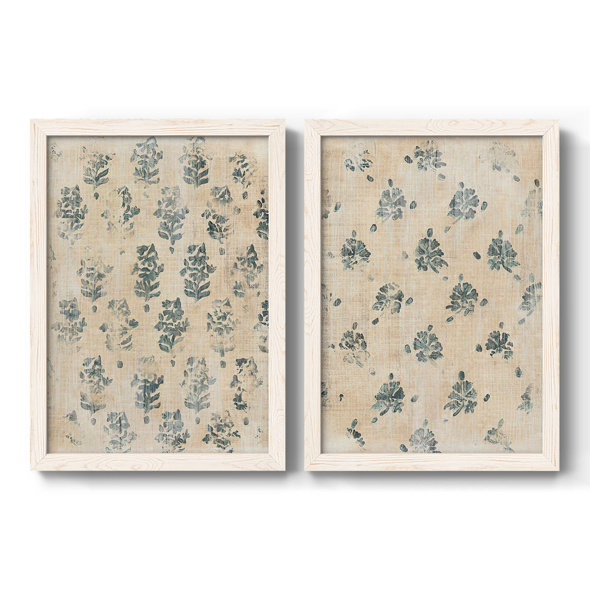 Set of two white barnwood framed canvas prints featuring two weathered block-print patterns featuring small repeating blue floral motifs.