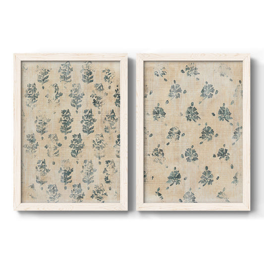 Set of two white barnwood framed canvas prints featuring two weathered block-print patterns featuring small repeating blue floral motifs.