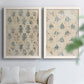 Set of two white barnwood framed canvas prints depicting distressed cream grounds, indigo stamps, and antique textile character arranged across two complementary compositions above a sofa in a bright living space.