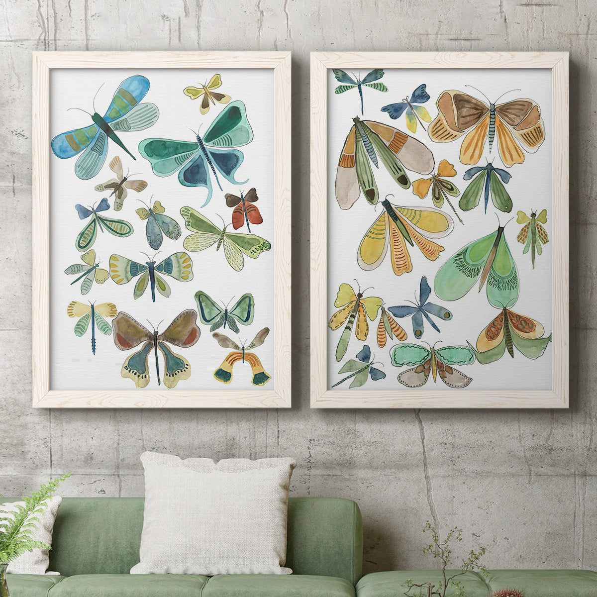 Set of two white barnwood framed canvas prints depicting a coordinated art pair of collections of moths and butterflies rendered as decorative insect illustrations above a sofa in a modern living room.