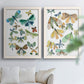 Set of two white barnwood framed canvas prints depicting patterned wings, leafy accents, and softly vintage natural-history styling arranged across two complementary compositions above a sofa in a bright living space.