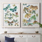 Set of two white barnwood framed canvas prints depicting a coordinated art pair of collections of moths and butterflies rendered as decorative insect illustrations above a dining room sideboard.