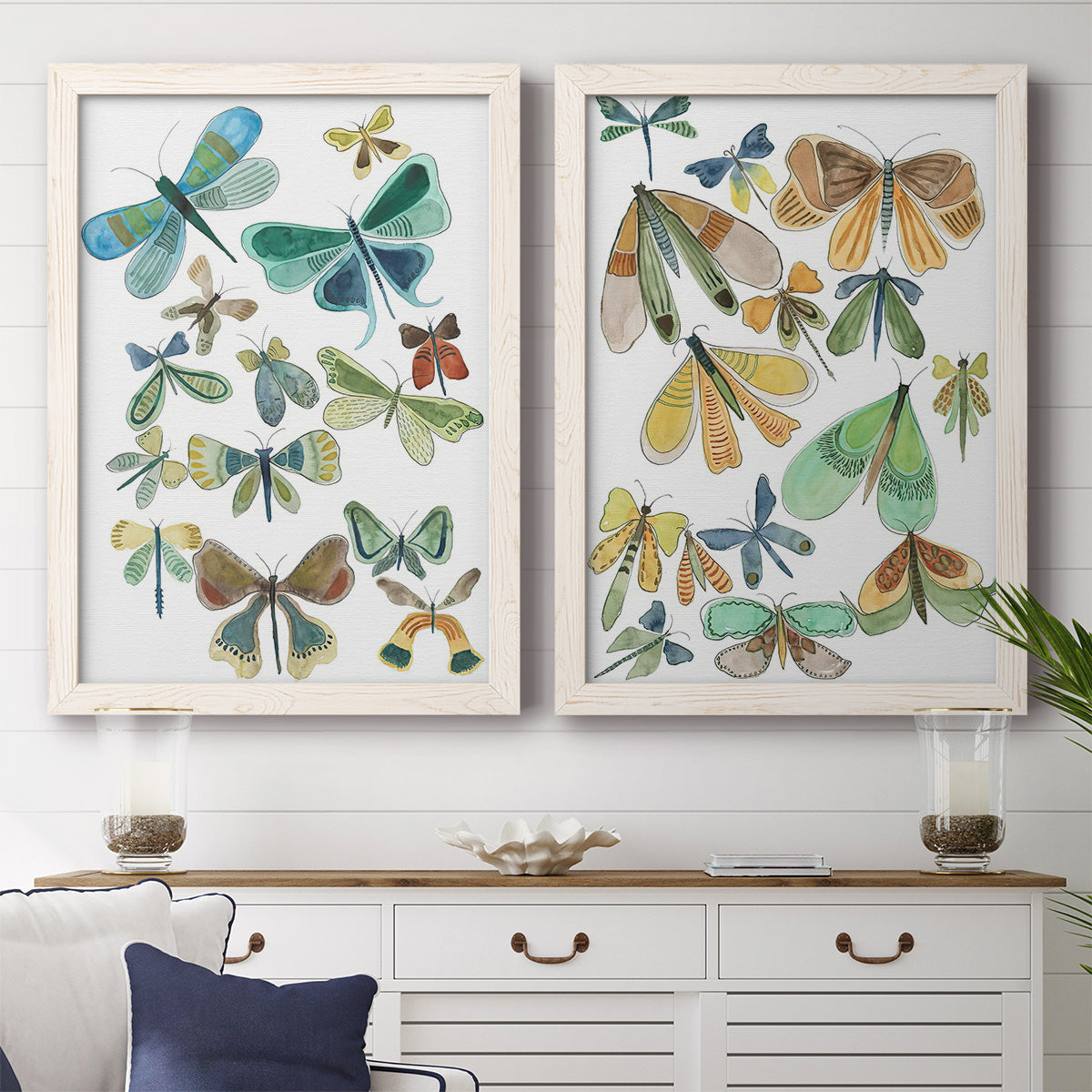 Set of two white barnwood framed canvas prints depicting a coordinated art pair of collections of moths and butterflies rendered as decorative insect illustrations above a dining room sideboard.
