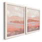 Angled view of a set of two white barnwood framed canvas prints featuring two modern abstract landscapes featuring layered blush terracotta and blue desert horizons.
