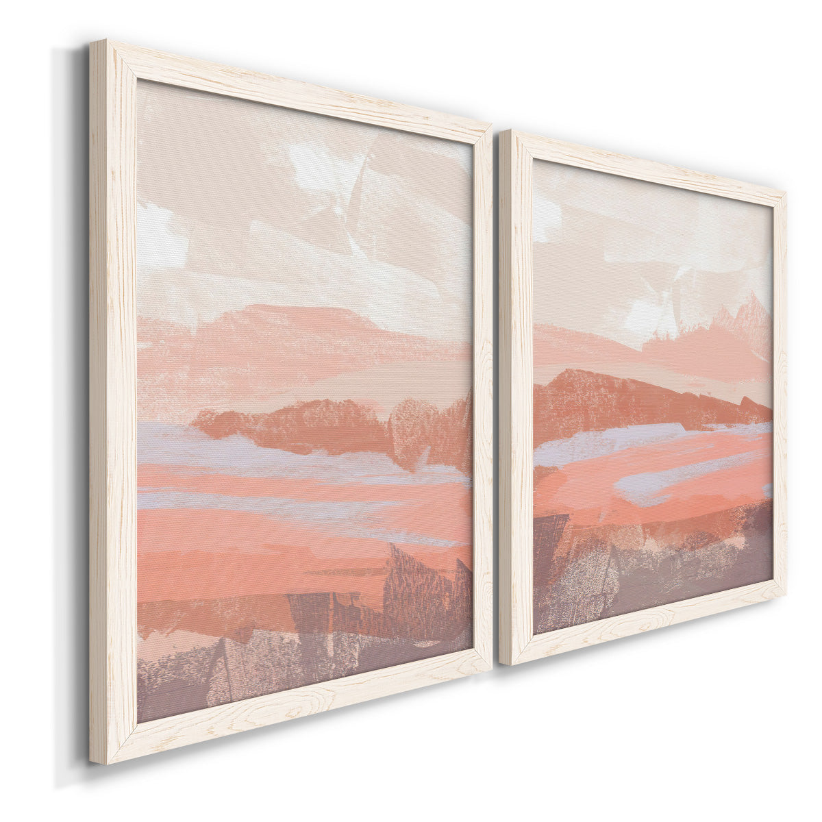 Angled view of a set of two white barnwood framed canvas prints featuring two modern abstract landscapes featuring layered blush terracotta and blue desert horizons.