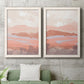 Set of two white barnwood framed canvas prints depicting a coordinated art pair of layered blush terracotta and blue desert horizons rendered as modern abstract landscapes above a sofa in a modern living room.