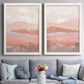 Set of two white barnwood framed canvas prints depicting paired modern abstract landscapes with low mountain silhouettes, horizontal bands, and muted atmospheric color above a sofa in a contemporary living room.