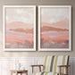 Set of two white barnwood framed canvas prints depicting two modern abstract landscapes featuring layered blush terracotta and blue desert horizons above a sideboard in a cozy sitting room.