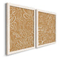 Angled view of a set of two white barnwood framed canvas prints featuring two graphic botanical pattern abstracts featuring continuous white organic lines over solid ochre and blush fields.