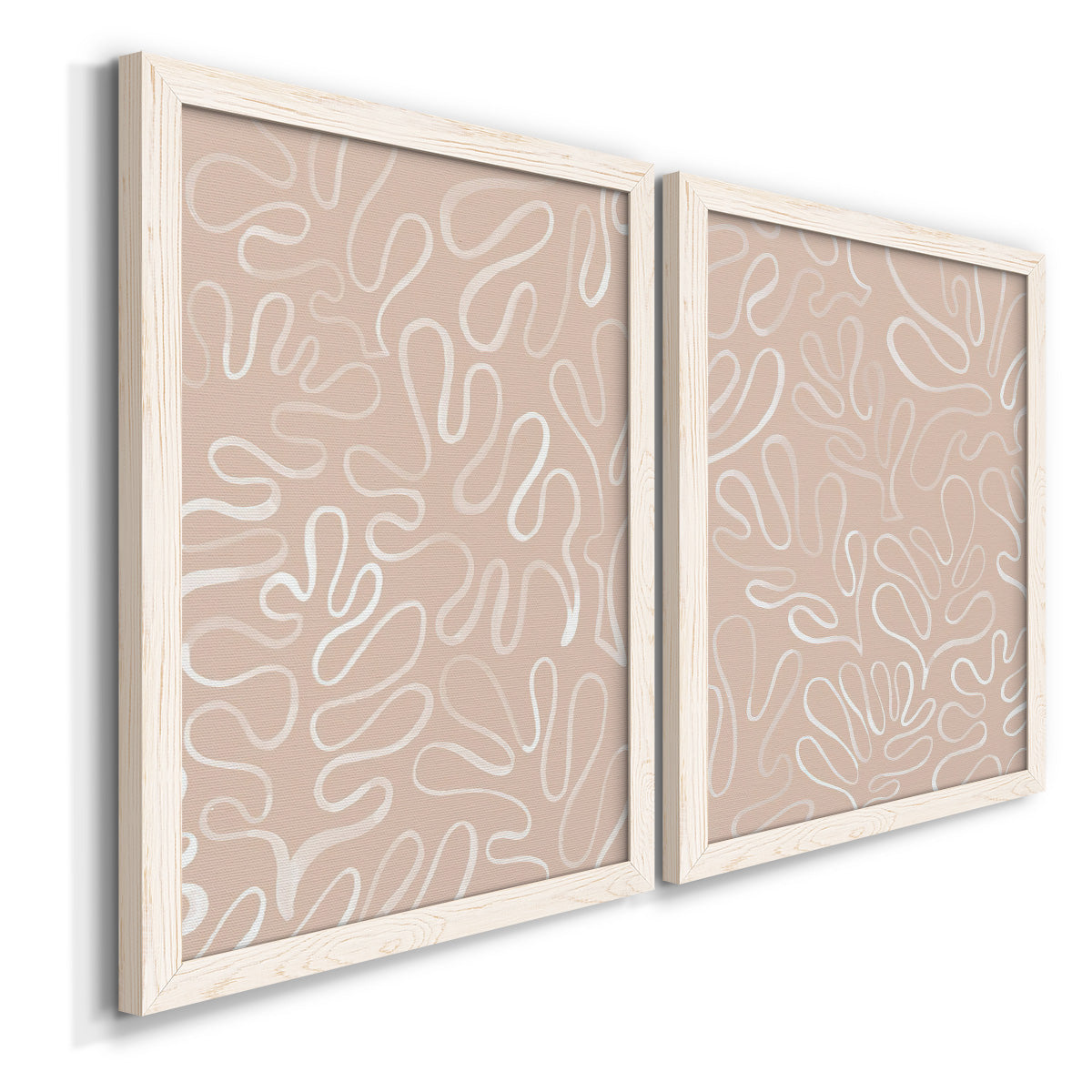 Angled view of a set of two white barnwood framed canvas prints featuring two graphic botanical pattern abstracts featuring continuous white organic lines over solid ochre and blush fields.
