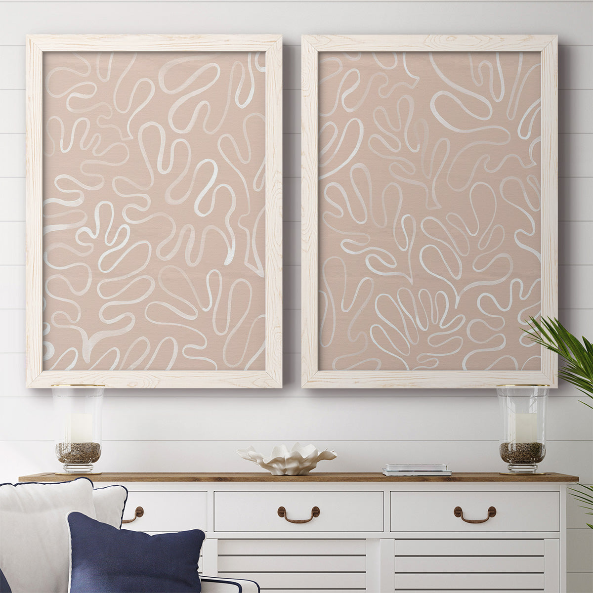 Set of two white barnwood framed canvas prints depicting a coordinated art pair of continuous white organic lines over solid ochre and blush fields rendered as graphic botanical pattern abstracts above a dining room sideboard.