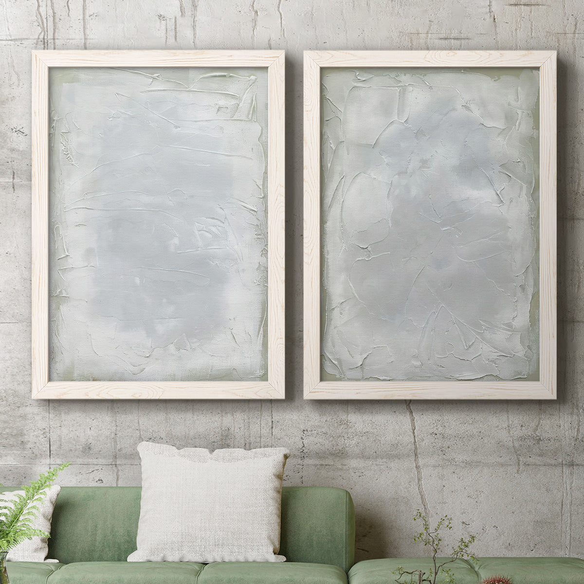 Set of two white barnwood framed canvas prints depicting a coordinated art pair of layered white and silver-gray painted surfaces rendered as quiet textural abstracts above a sofa in a modern living room.
