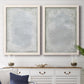 Set of two white barnwood framed canvas prints depicting a coordinated art pair of layered white and silver-gray painted surfaces rendered as quiet textural abstracts above a dining room sideboard.