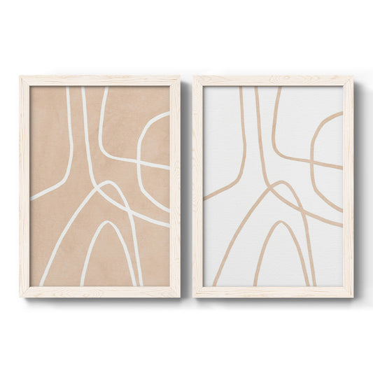 Set of two white barnwood framed canvas prints featuring two minimalist line abstracts featuring single continuous tan lines forming oversized organic curves.