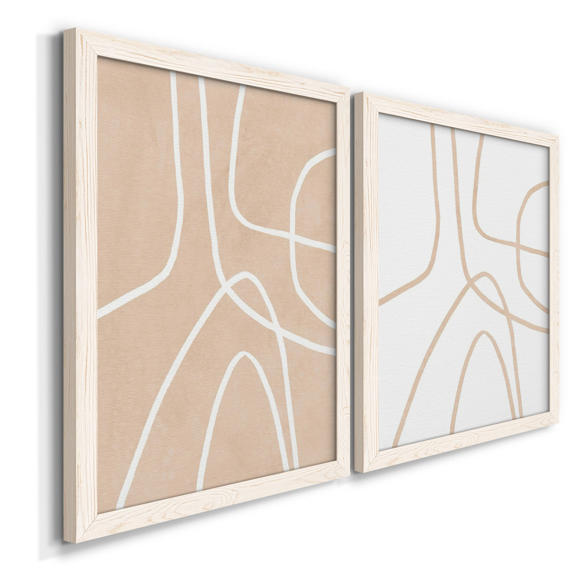 Angled view of a set of two white barnwood framed canvas prints featuring two minimalist line abstracts featuring single continuous tan lines forming oversized organic curves.