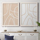 Set of two white barnwood framed canvas prints depicting a coordinated art pair of single continuous tan lines forming oversized organic curves rendered as minimalist line abstracts above a dining room sideboard.