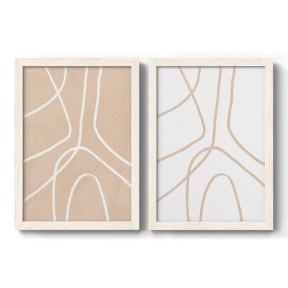 Set of two white barnwood framed canvas prints featuring two minimalist line abstracts featuring single continuous tan lines forming oversized organic curves.
