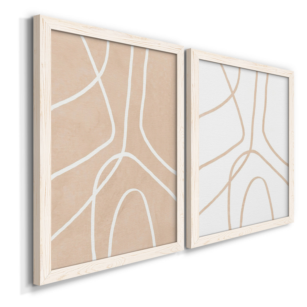 Angled view of a set of two white barnwood framed canvas prints featuring two minimalist line abstracts featuring single continuous tan lines forming oversized organic curves.