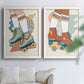 Set of two white barnwood framed canvas prints depicting orange teal and blue skates, star details, and graphic geometric accents arranged across two complementary compositions above a sofa in a bright living space.