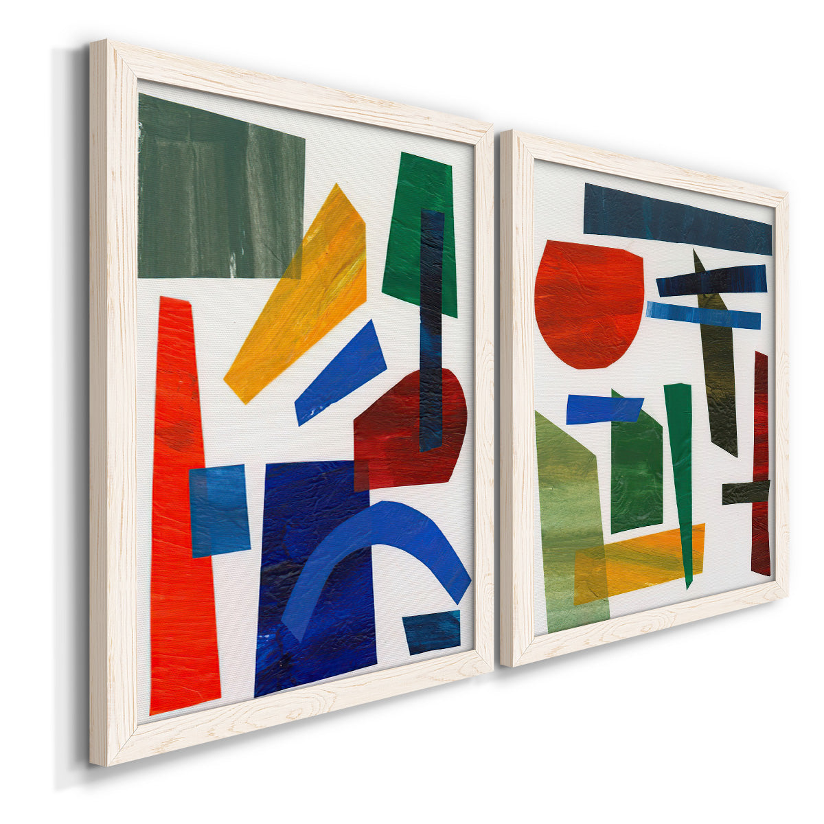 Angled view of a set of two white barnwood framed canvas prints featuring two mid-century graphic abstracts featuring bold red blue green yellow and black geometric forms.