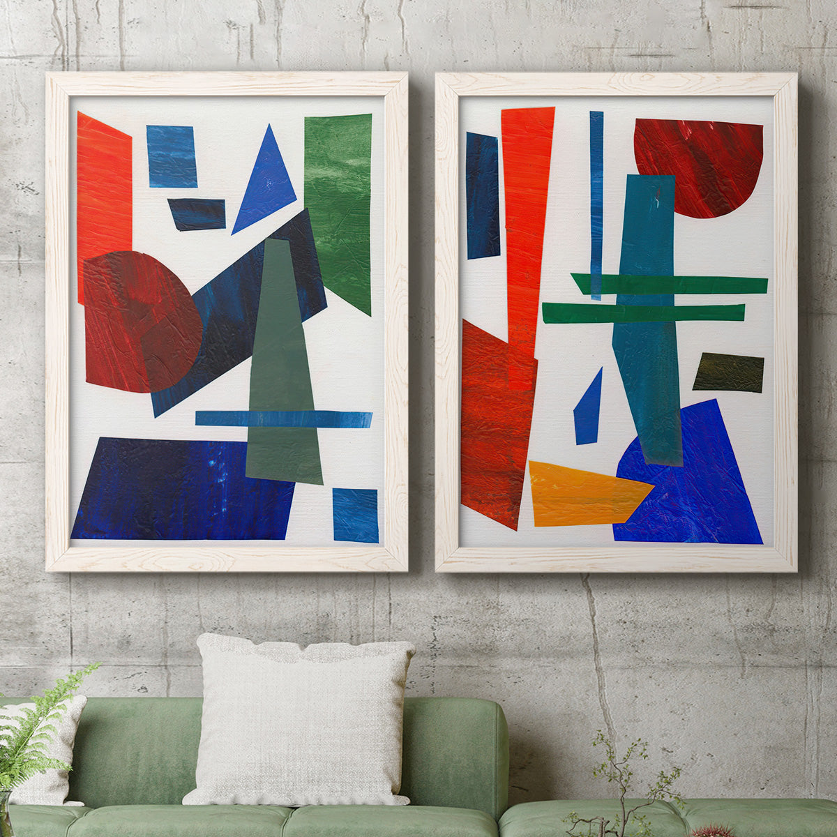Set of two white barnwood framed canvas prints depicting a coordinated art pair of bold red blue green yellow and black geometric forms rendered as mid-century graphic abstracts above a sofa in a modern living room.