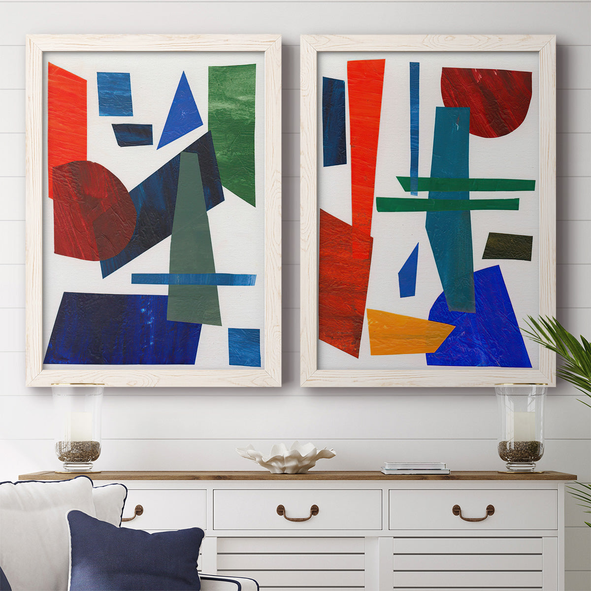 Set of two white barnwood framed canvas prints depicting a coordinated art pair of bold red blue green yellow and black geometric forms rendered as mid-century graphic abstracts above a dining room sideboard.