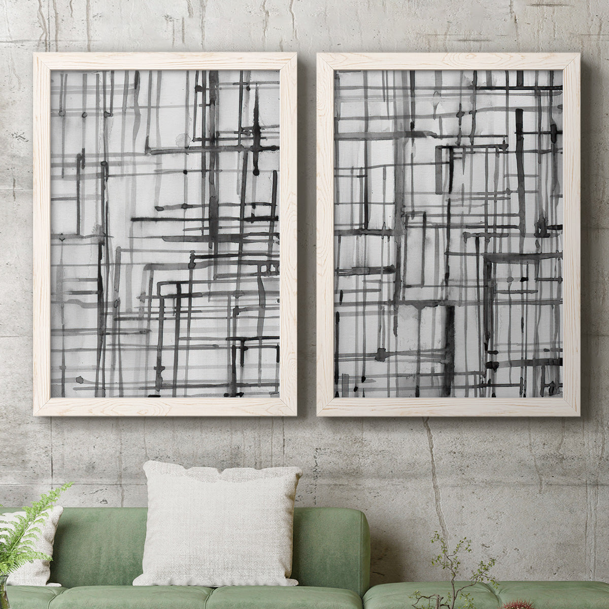 Set of two white barnwood framed canvas prints depicting a coordinated art pair of layered black linear grids rendered as monochrome geometric abstracts above a sofa in a modern living room.