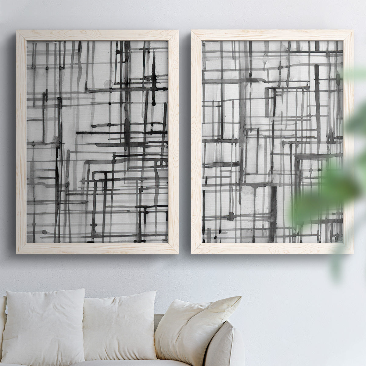 Set of two white barnwood framed canvas prints depicting overlapping rectangles, hand-drawn verticals, and transparent gray intersections arranged across two complementary compositions above a sofa in a bright living space.