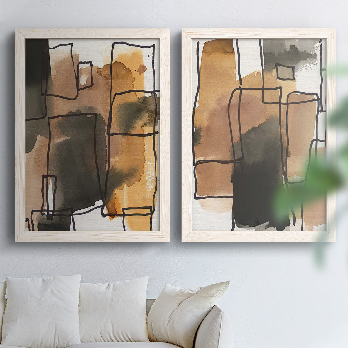 Set of two white barnwood framed canvas prints depicting tan brown gray and cream shapes with loose rectangular structure arranged across two complementary compositions above a sofa in a bright living space.