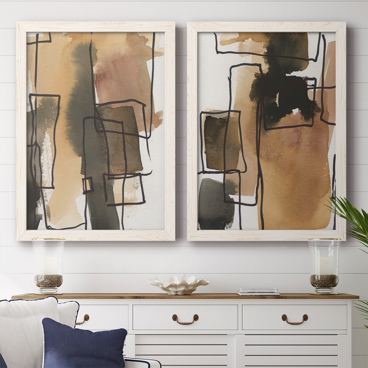 Set of two white barnwood framed canvas prints depicting a coordinated art pair of earthy watercolor blocks crossed by black contour lines rendered as retro geometric abstracts above a dining room sideboard.