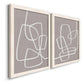 Angled view of a set of two white barnwood framed canvas prints featuring two minimalist geometric line art featuring overlapping white continuous-line loops on taupe.