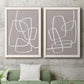 Set of two white barnwood framed canvas prints depicting a coordinated art pair of overlapping white continuous-line loops on taupe rendered as minimalist geometric line art above a sofa in a modern living room.