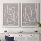 Set of two white barnwood framed canvas prints depicting a coordinated art pair of overlapping white continuous-line loops on taupe rendered as minimalist geometric line art above a dining room sideboard.
