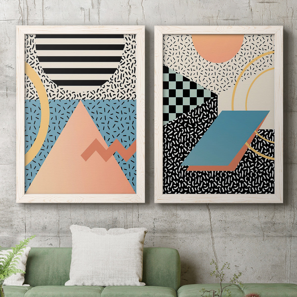 Set of two white barnwood framed canvas prints depicting a coordinated art pair of bold geometric Memphis-style patterns rendered as retro graphic abstracts above a sofa in a modern living room.