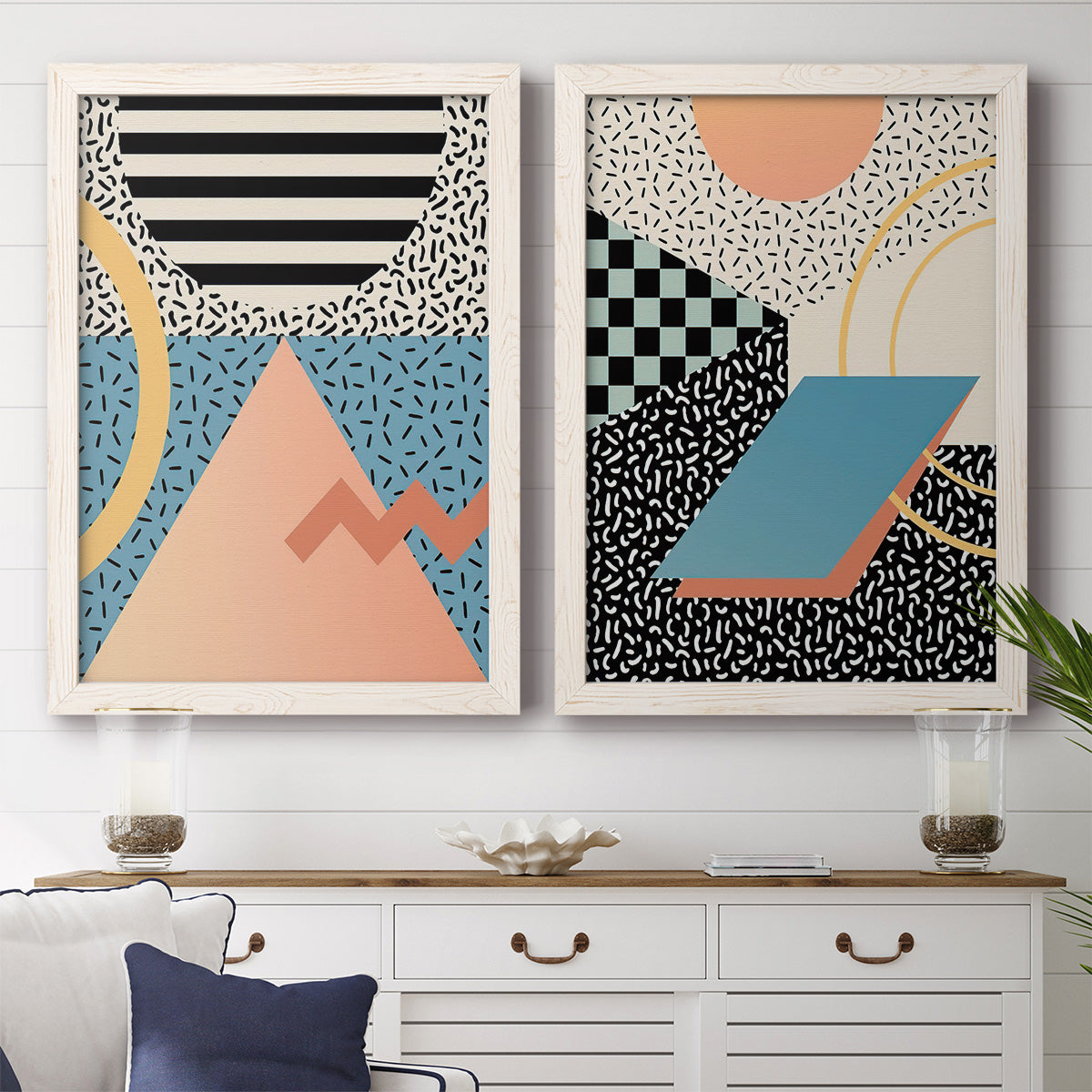 Set of two white barnwood framed canvas prints depicting a coordinated art pair of bold geometric Memphis-style patterns rendered as retro graphic abstracts above a dining room sideboard.