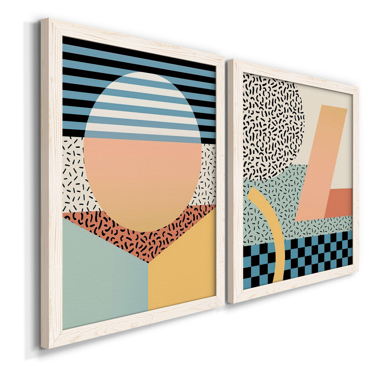 Angled view of a set of two white barnwood framed canvas prints featuring two retro graphic abstracts featuring bold geometric Memphis-style patterns.