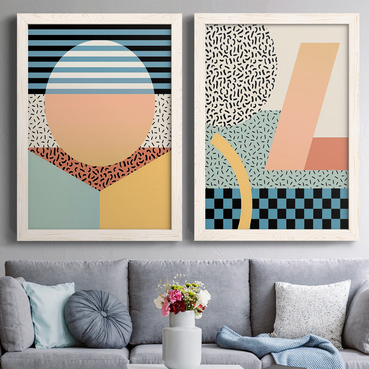 Set of two white barnwood framed canvas prints depicting paired retro graphic abstracts with checkerboards stripes squiggles peach blue black and mint shapes above a sofa in a contemporary living room.