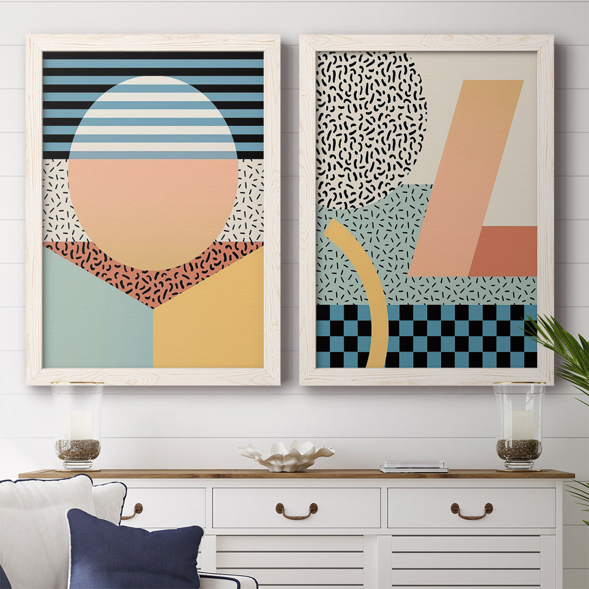 Set of two white barnwood framed canvas prints depicting a coordinated art pair of bold geometric Memphis-style patterns rendered as retro graphic abstracts above a dining room sideboard.