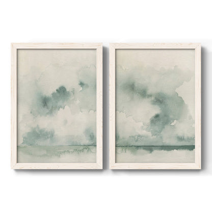Set of two white barnwood framed canvas prints featuring two minimalist watercolor seascapes with misty green clouds calm horizons and pale reflective water.