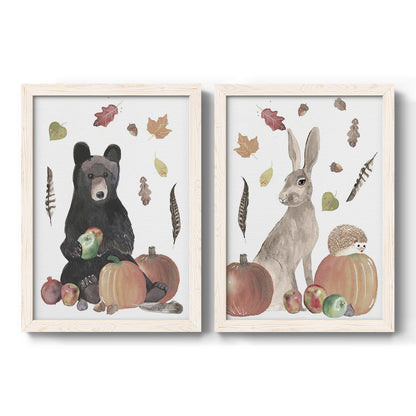 Set of two white barnwood framed canvas prints featuring a watercolor woodland animal pair with a bear rabbit hedgehog pumpkins fruit acorns and falling leaves.