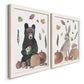 Angled view of a set of two white barnwood framed canvas prints featuring a watercolor woodland animal pair with a bear rabbit hedgehog pumpkins fruit acorns and falling leaves.