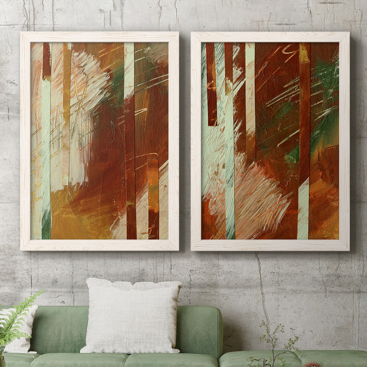 Set of two white barnwood framed canvas prints depicting a coordinated art pair of rust orange black cream and green brush bands rendered as earthy modern abstracts above a sofa in a modern living room.