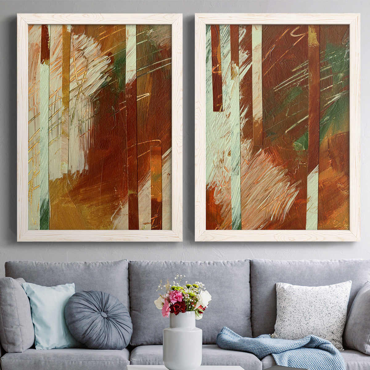 Set of two white barnwood framed canvas prints depicting paired earthy modern abstracts with vertical stripes, scraped paint, and weathered layered texture above a sofa in a contemporary living room.